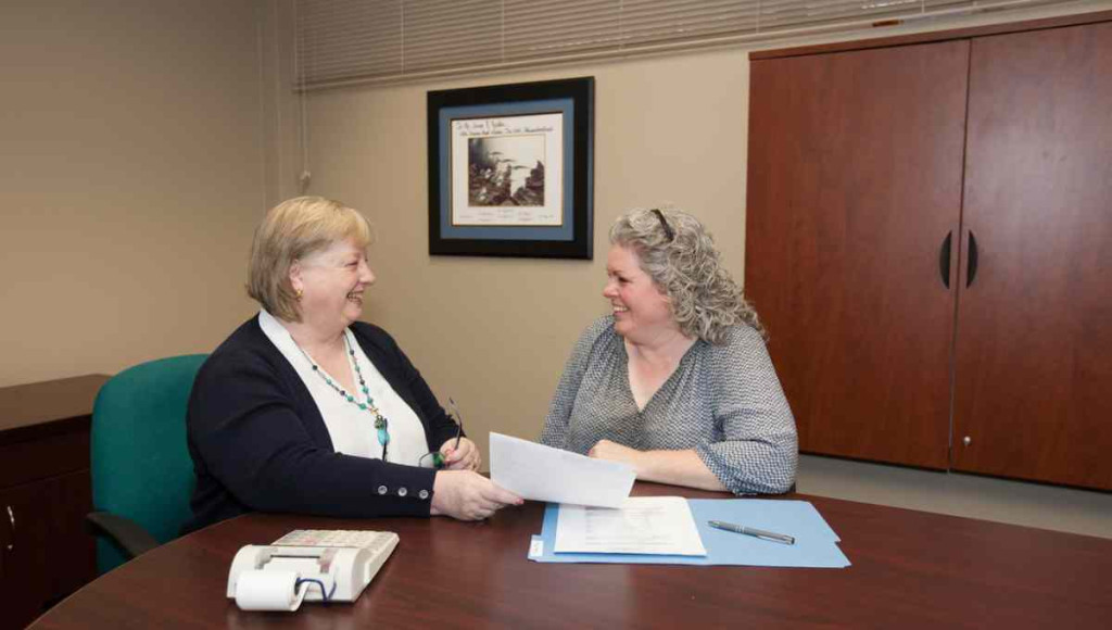Bookkeeper meets with small business owner about year-end bookkeeping tasks