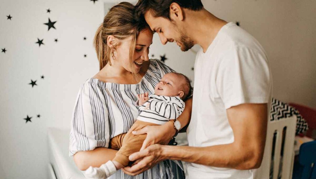 Parents holding their newborn baby at home, representing how Washington PFML changes in 2026 may impact small business owners and families.